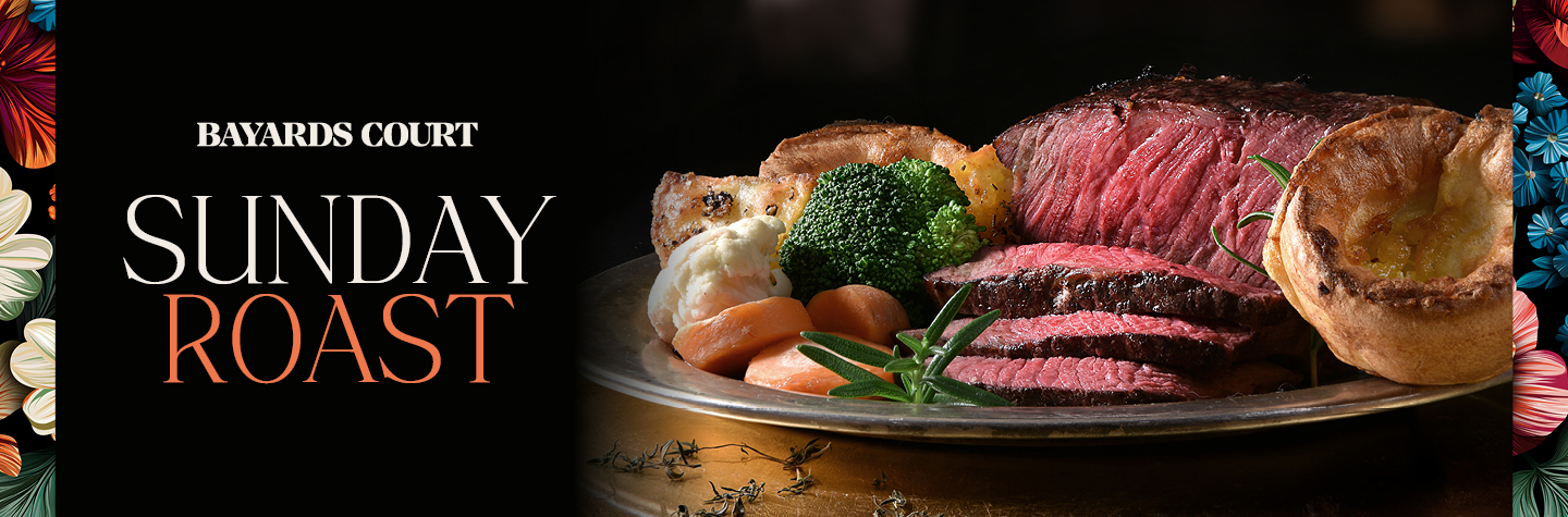 A plate featuring a Sunday roast with succulent meat and colorful vegetables arranged artfully.