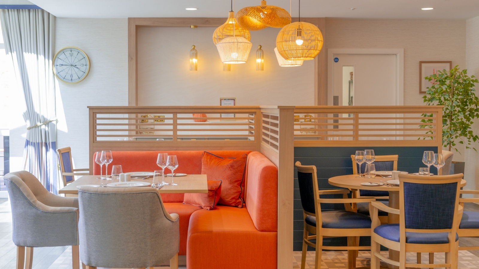 A restaurant interior featuring orange and blue chairs and tables, creating a vibrant and inviting atmosphere.