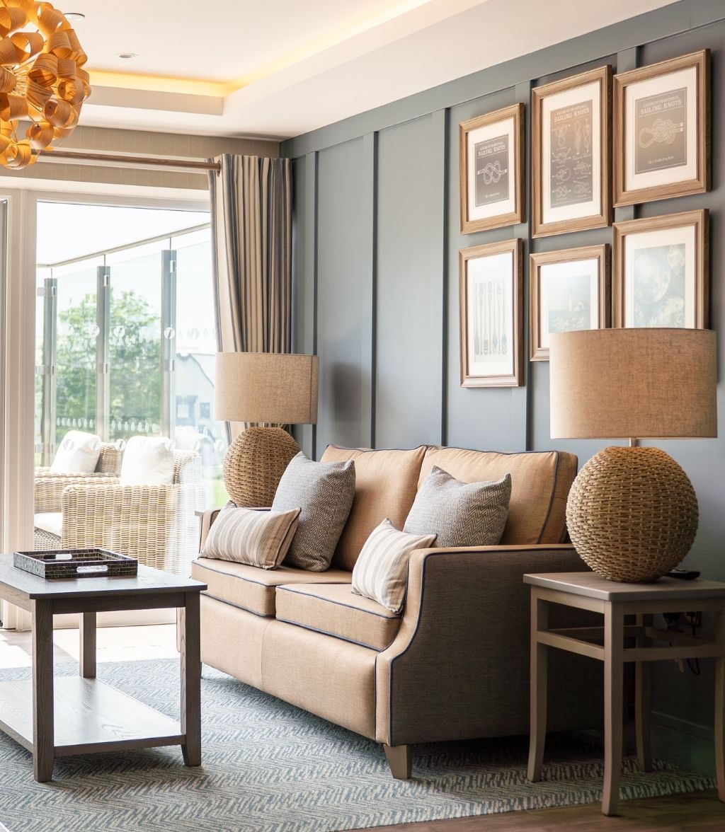A cosy living room featuring a sofa, coffee table, and a lamp, creating a warm and inviting atmosphere.