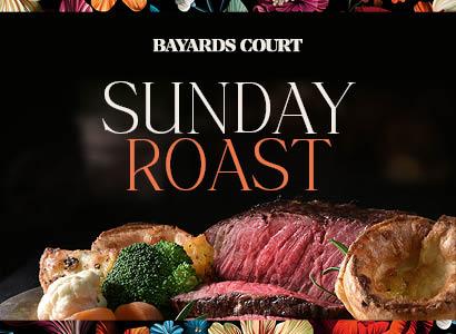 A plate featuring a Sunday roast with succulent meat and colorful vegetables arranged artfully.